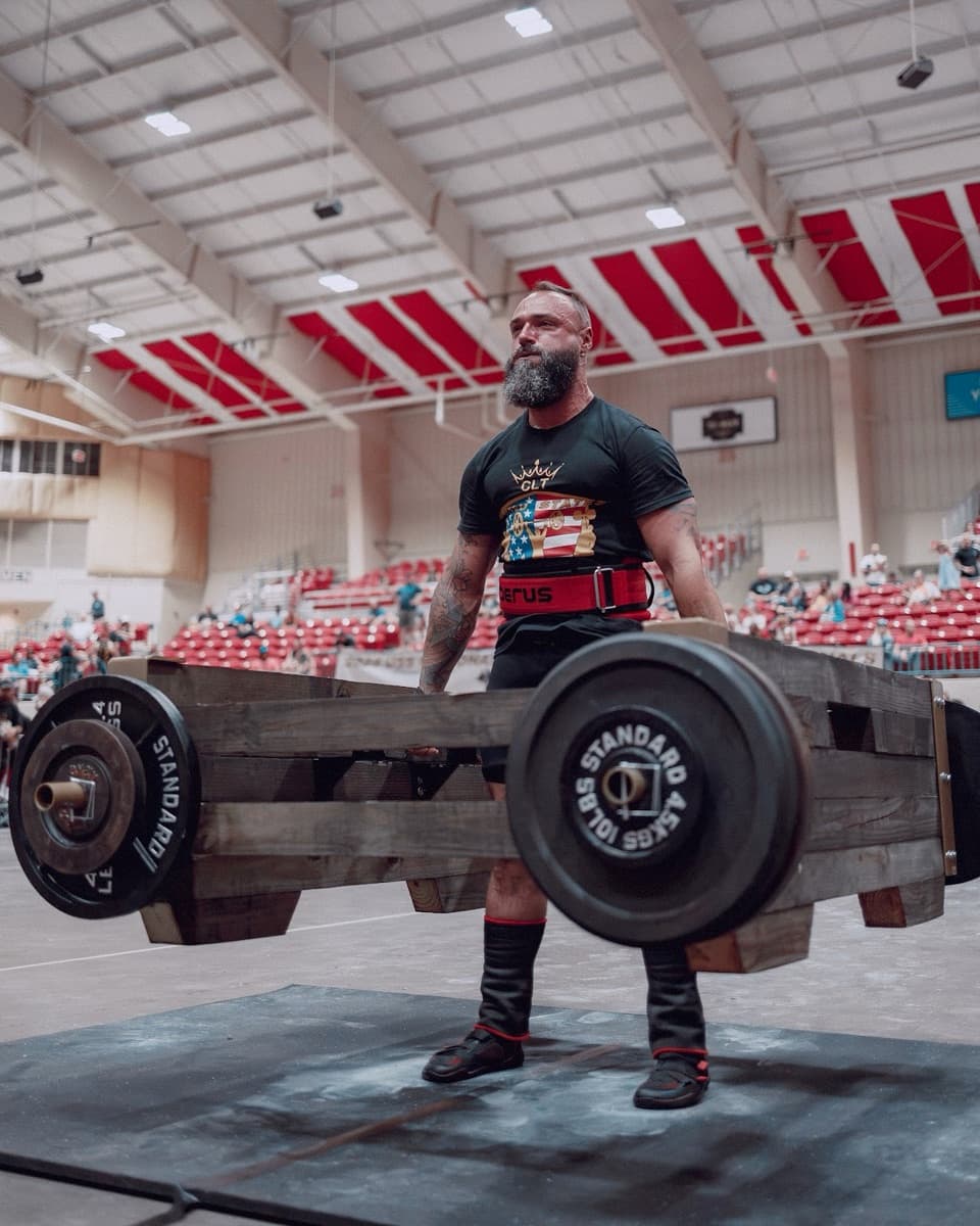 Sean holding a loaded frame at lockout on the competition floor.