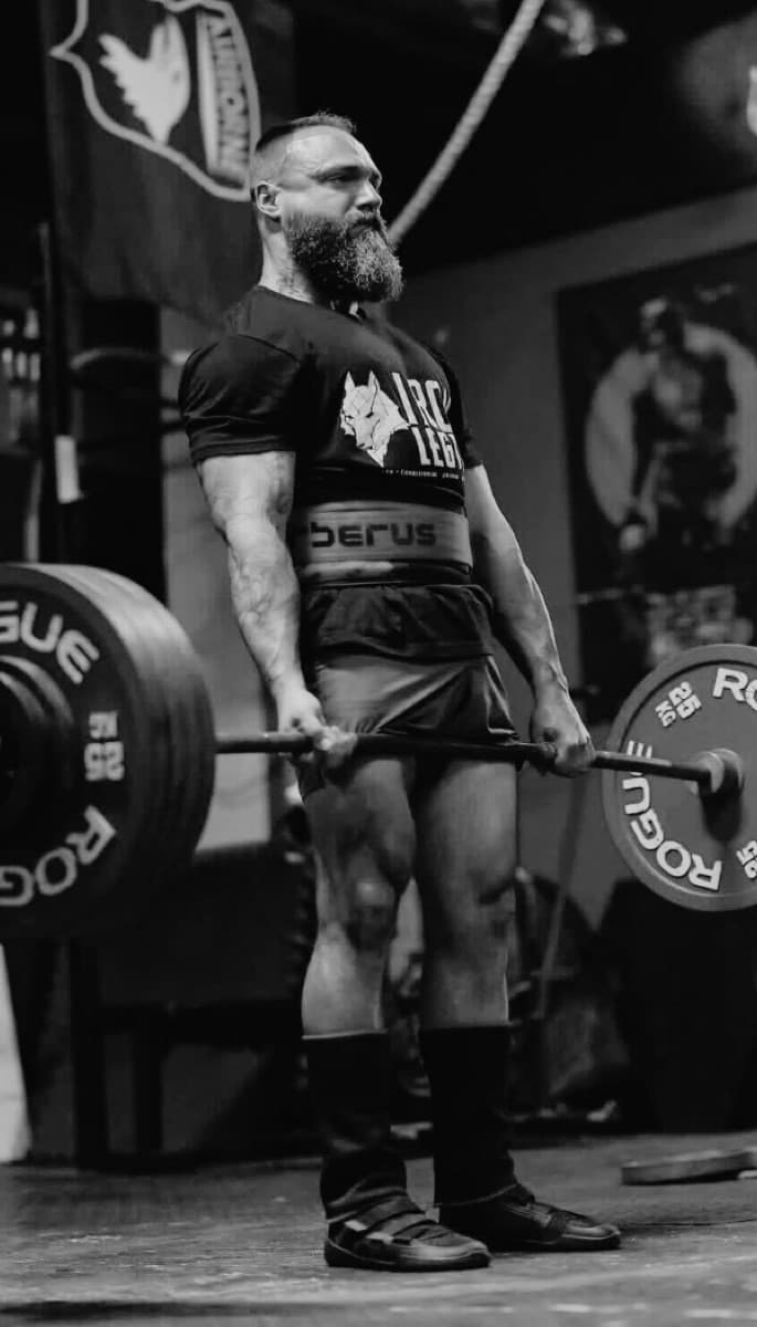 Deadlift held at lockout, shot in black and white.